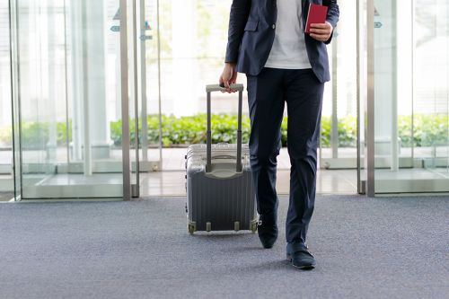 Mann mit Koffer am Flughafen